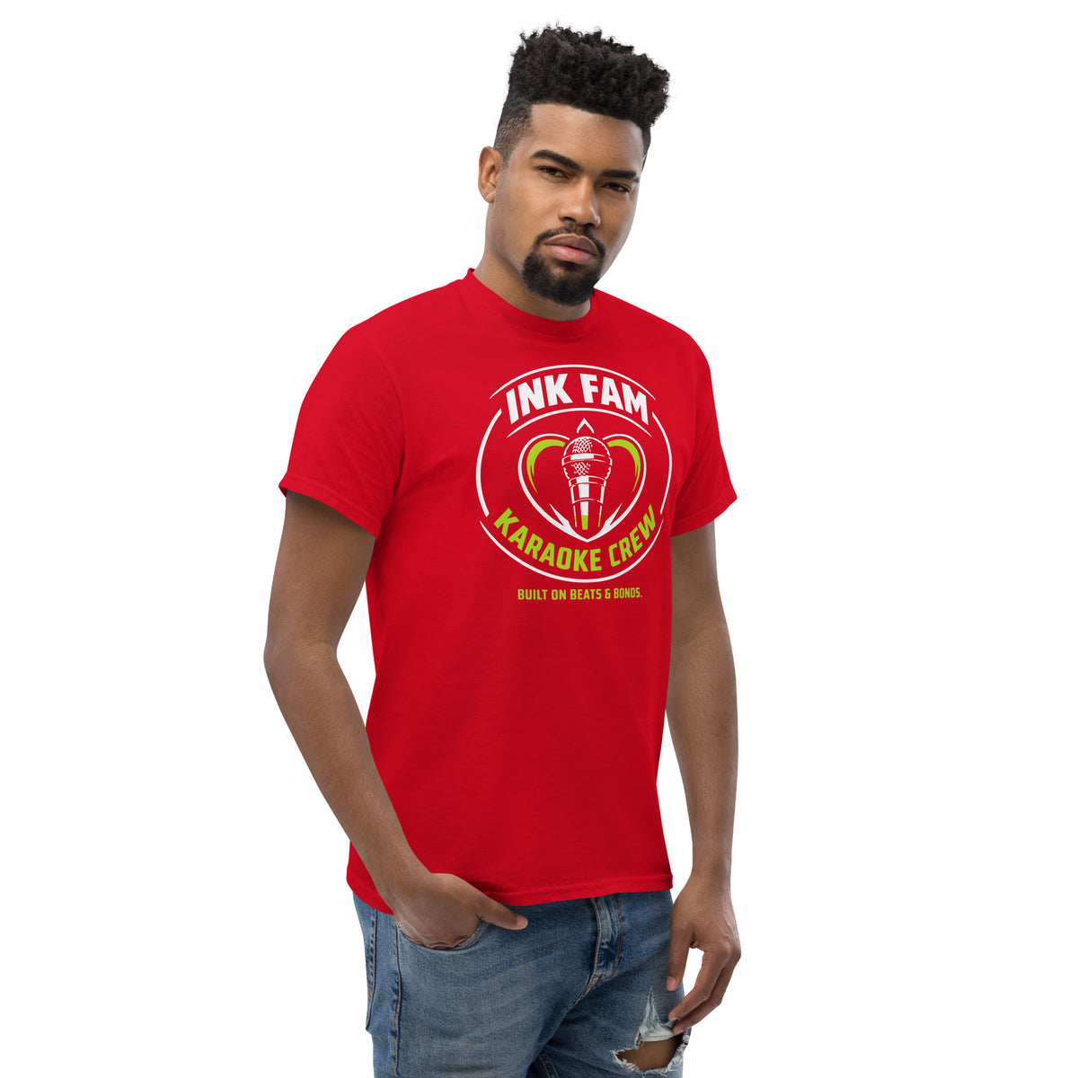 Red classic T-shirt, right-front angled view, featuring DJ Ink Fam green-and-white circular microphone badge.