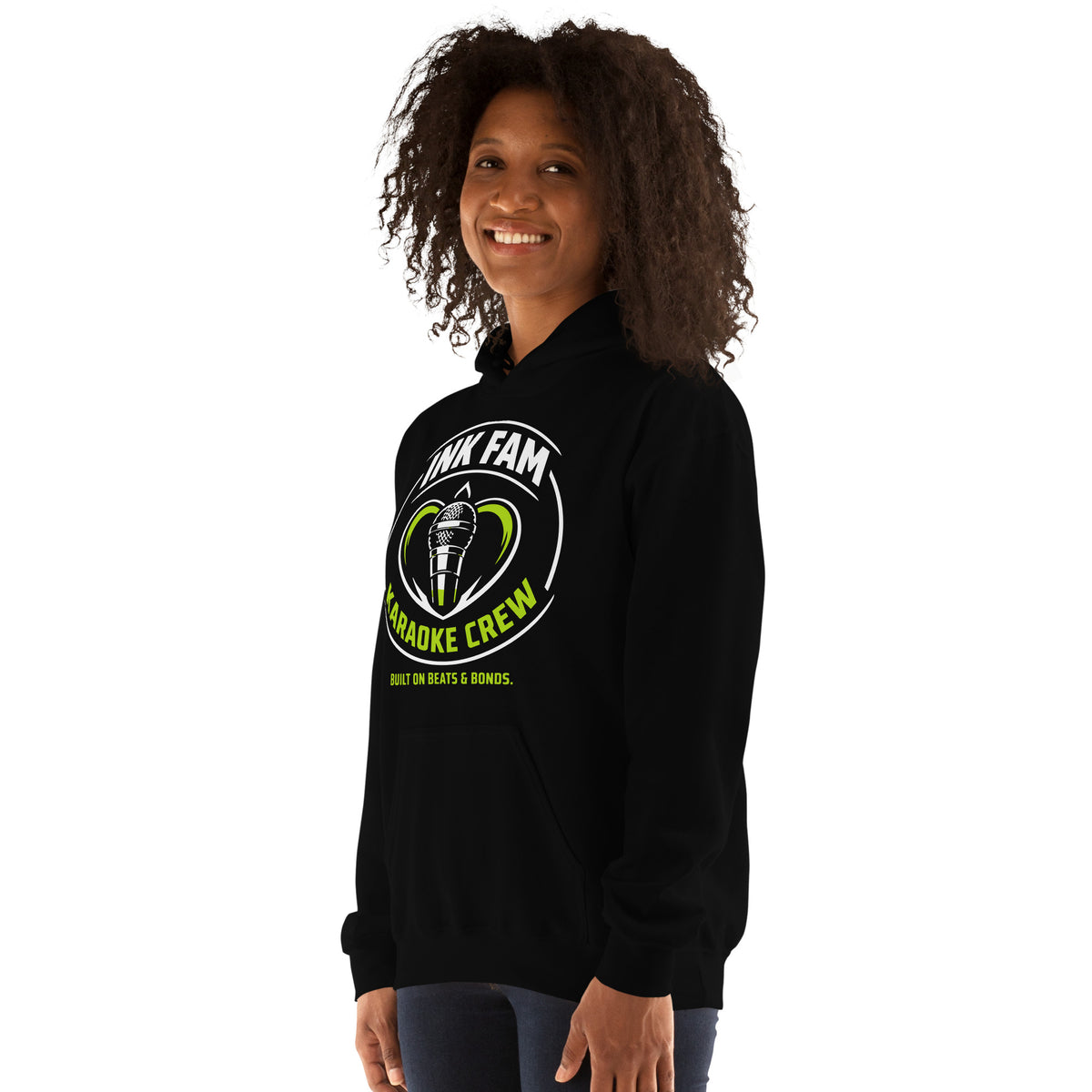 Black pullover hoodie, left-front angled view, featuring the green-and-white circular DJ Ink Fam microphone badge.