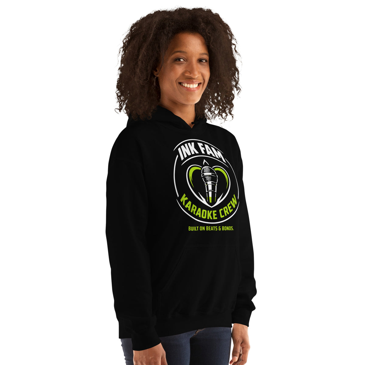 Black pullover hoodie, right-front angled view, featuring the green-and-white circular DJ Ink Fam microphone badge.