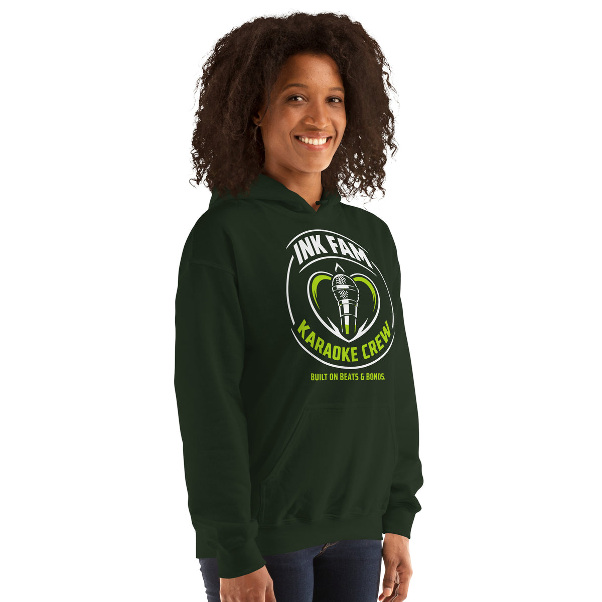 Forest Green pullover hoodie, right-front angled view, featuring the green-and-white circular DJ Ink Fam microphone badge.