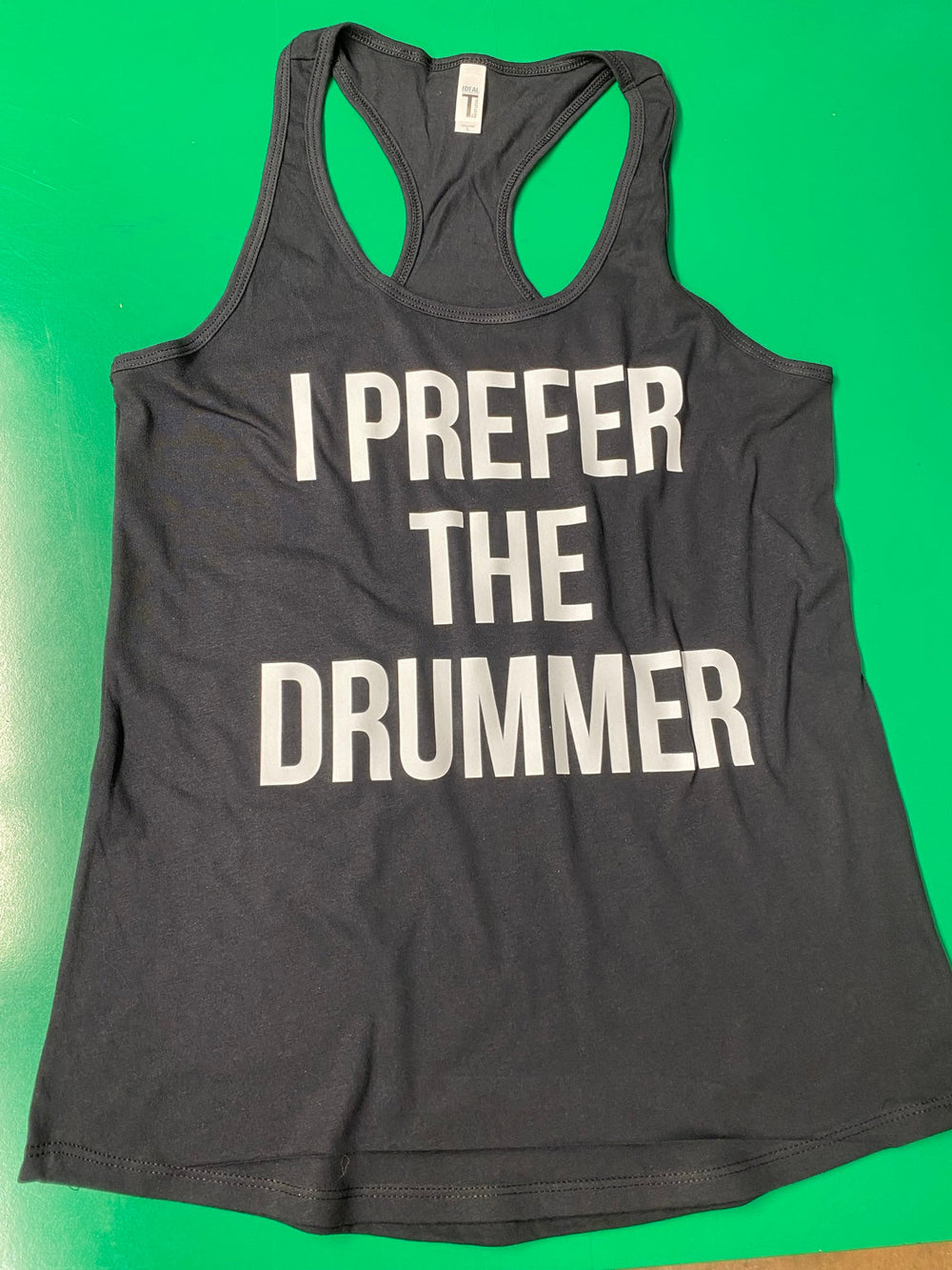 Dark racerback tank top with large white lettering reading I Prefer the Drummer.