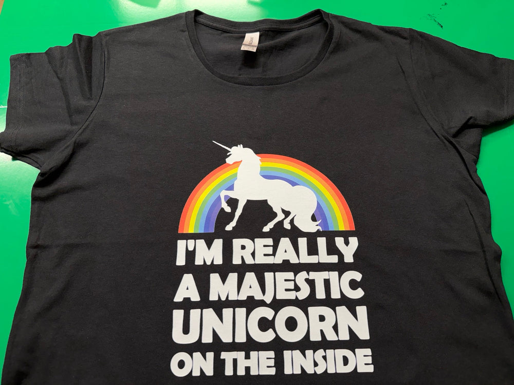 Black T-shirt with a white unicorn, rainbow, and the words I'm Really a Majestic Unicorn on the Inside, printed by Minty Tees.
