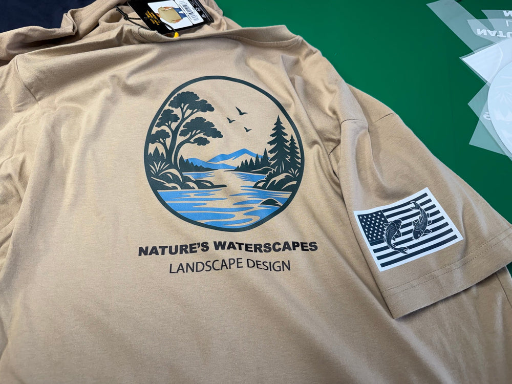 Tan Nature’s Waterscapes Landscape Design work shirt showing its landscape back print and flag-and-fish sleeve print.