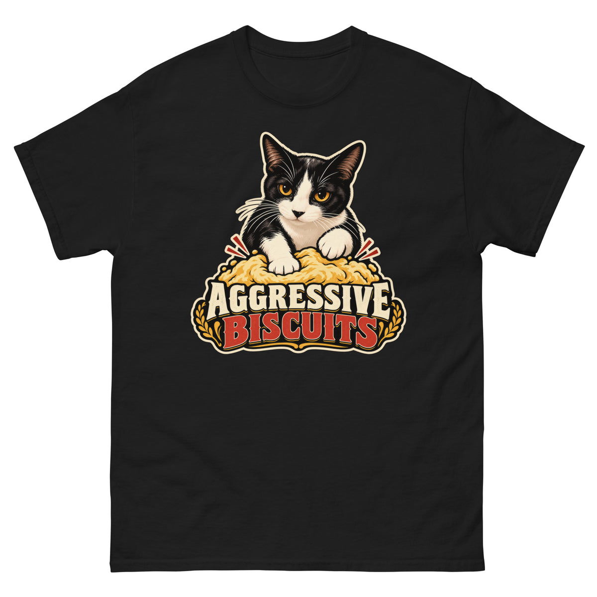 Black classic T-shirt, front view, featuring a black and white tuxedo cat with amber eyes kneading a mound of golden dough, under vintage bakery badge lettering reading Aggressive Biscuits